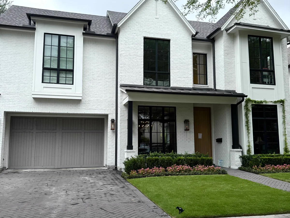 A clean two-story brick home with a freshly washed driveway.