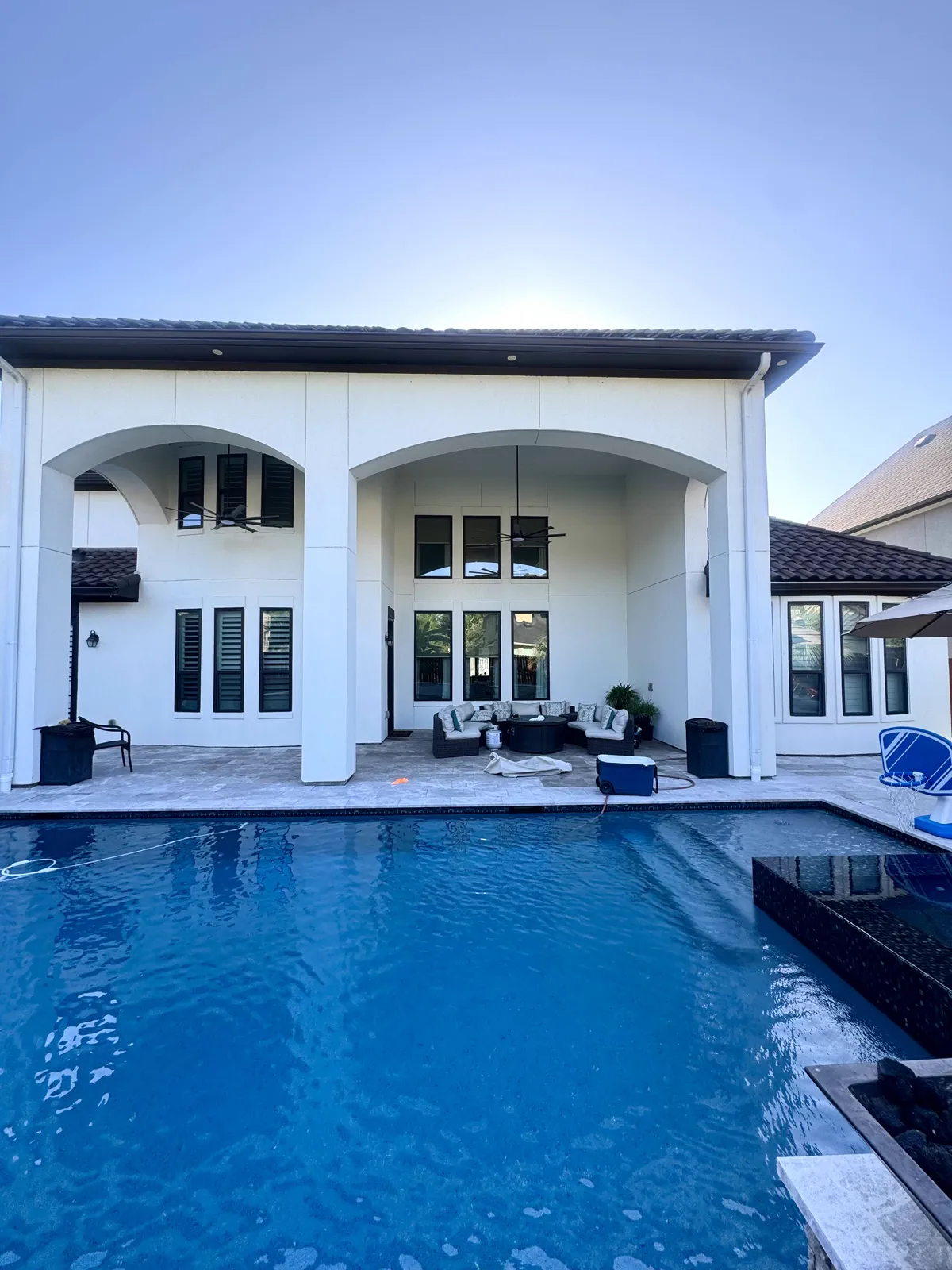 Backyard pool and patio glowing at dusk after a Double Tap exterior clean